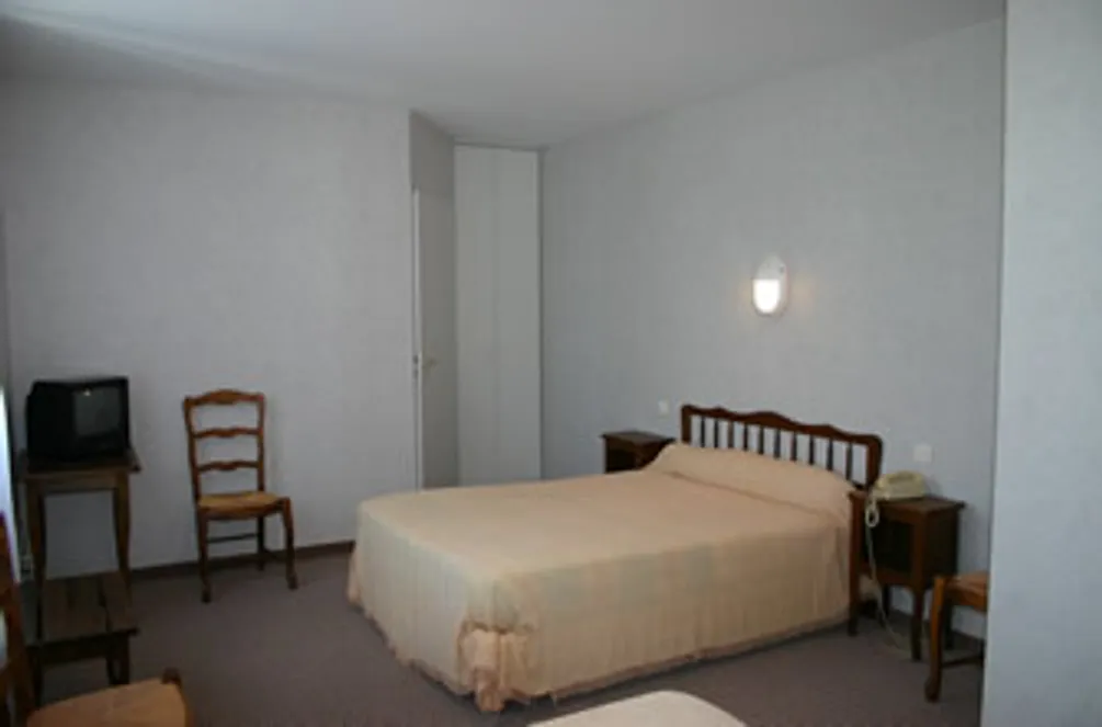 Chambre avec lit, télévision et chaise